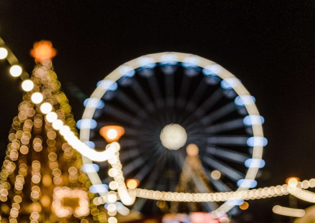 Luzes, roda-gigante e árvore de Natal num mercado natalício