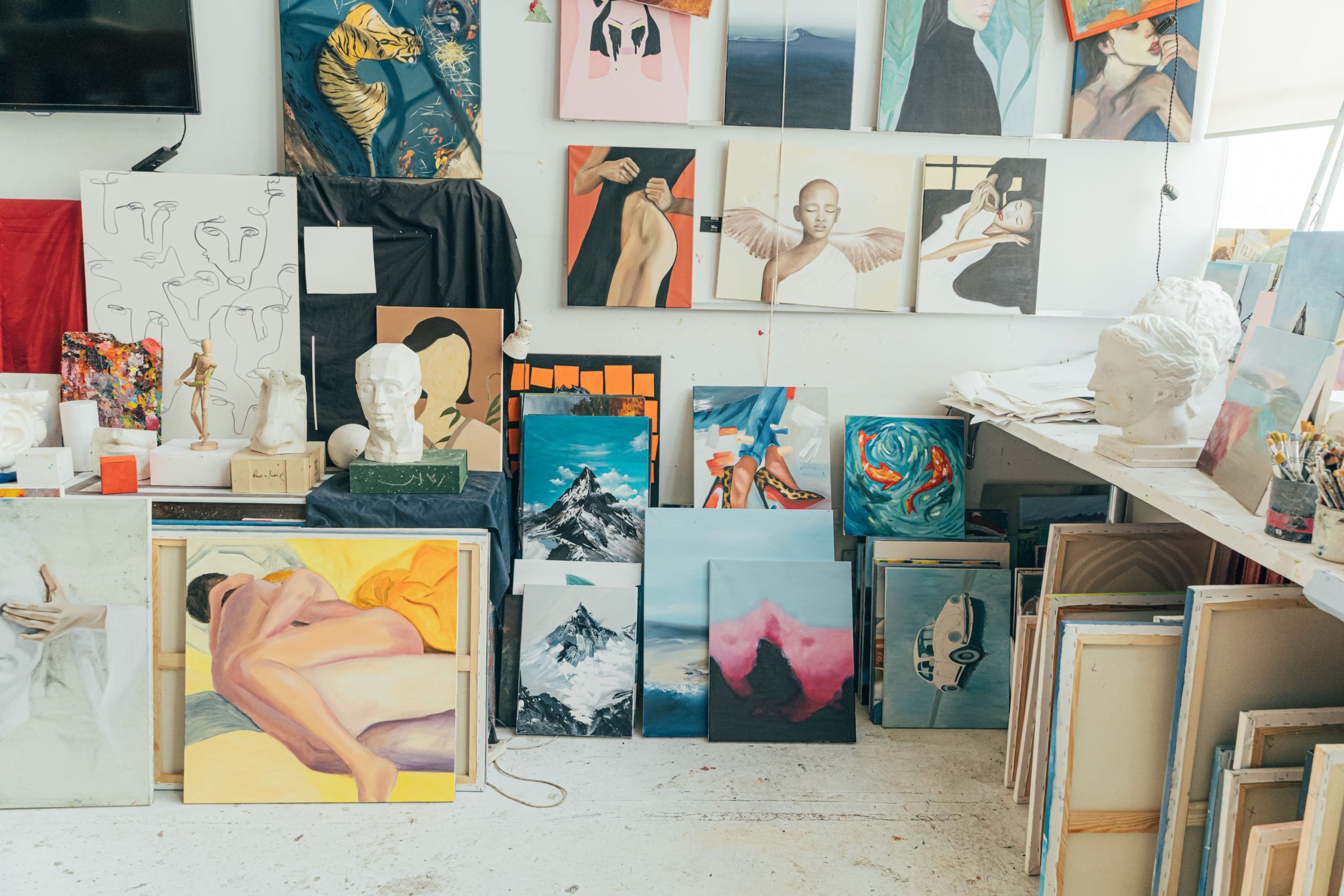 Mulher junto a pinturas e obras de arte num espaço interior