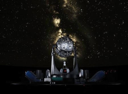 Fotografia do interior do Planetário Calouste Gulbenkian em Lisboa, mostrando um projetor de estrelas em frente a uma projeção do céu noturno repleto de estrelas. A imagem captura a atmosfera imersiva e educativa do planetário, ideal para promover visitas e eventos no Planetário Calouste Gulbenkian em Lisboa.