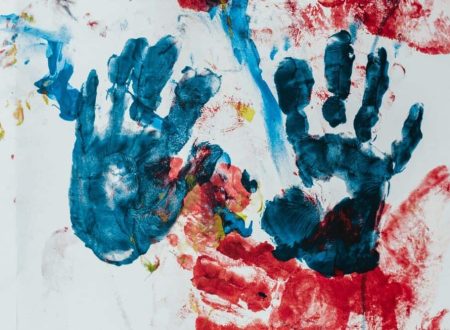 Imagem de impressões de mãos coloridas em tinta azul e vermelha sobre um papel branco, representando uma atividade criativa infantil. Ideal para destacar eventos e atividades para crianças na agenda infantil de Lisboa
